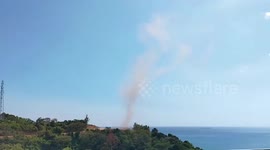 Enormous dust devil forms off cliff astonishing tourists