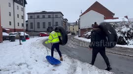 Wales residents carry toboggans and inflatable donuts as heavy snow falls