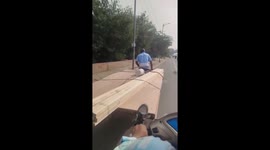 Motorcyclist gives elderly man manually transporting wood a helpful boost