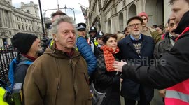 Police escort Jeremy Corbyn as people heckle former Labour leader during London rally