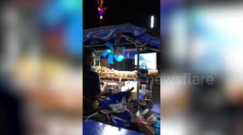 Gamer street vendor plays Call of Duty in food stall during lull at work