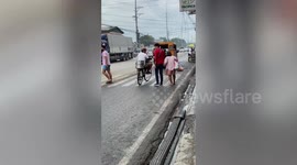 Kind pedestrian stops traffic to help elderly woman cross road