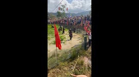 Blindfolded people join game aimed at catching as many ducks as possible in flooded rice fields