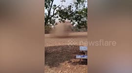 Terrifying dust devil whips up debris next to children in park
