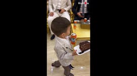 Kid's loose grip smashes cake to the floor; click to watch his epic reaction!