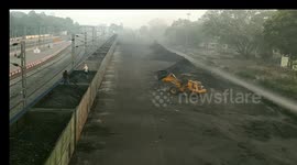 A worker operates a JCB machine to load coal onto a goods train at Sambalpur Hirakud railway station in the state of Odisha, India.