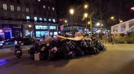 People walk by mountain of Trash / garbage in Paris in the evening during Pension Reforms Strike