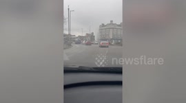 A water spout reaching 30 ft has nearly halted traffic as it sprayed across a busy road in south-east London