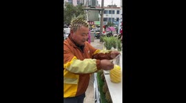 Chinese fruit vendor takes passion for his job to next level with pineapple haircut