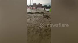 Raging Peru mudslide sweeps away furniture as it gushes down road