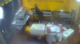 Shopkeeper battles to hold food display as storm hits building in Thailand