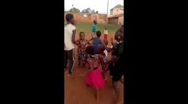 African child playing and having a happy time together with them, while others were playing football