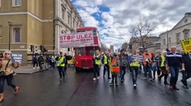 Anti-ULEZ protesters march along Whitehall with Routemaster bus
