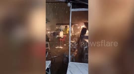 Street vendors battle to save stalls as driving rain and hail batters northern Thailand