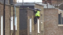 Workman spotted under the roof of a multi-storey buiding in Earls Court
