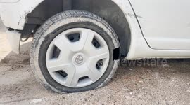 A Palestinian man inspects his car allegedly sprayed by Jewish settlersin the east Jerusalem neighborhood of Sheikh Jarrah