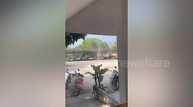 Dust devil tornado swirls outside home next to young boy