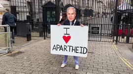 Activist wearing Benjamin Netanyahu mask holds 'I love apartheid' sign ahead of Israeli PM's UK visit