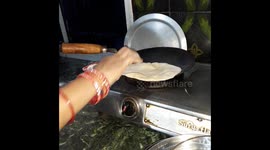 Indian house wife roti making  for home in gas stove . Village life