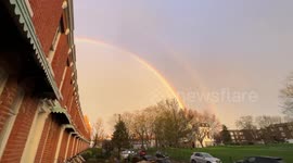As the sun begins to set and rain falls, a double rainbow falls over Peckham, south London