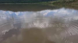 Slow motion throwing rock into water .Slow Motion throwing a Rock In Water, big ripples