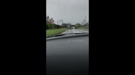 Heavy rain in the UK on 26 March causes road to flood. Dash cam footage as car goes through flooded road in Bedfordshire