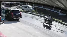 Motorcycle riders slip on accident-prone wet road in Thailand