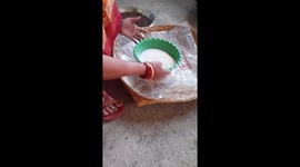 Rural Indian woman cleaning semolina in a strainer sitting at home