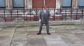 Elton John strikes a pose as he leaves court on day one of privacy case preliminary court hearings