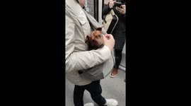 Adorable puppy dog carried in a special bag by his master in the Parisian subway to protect him from the crowd. Metro Tolbiac station, Paris, France. 28 march 2023