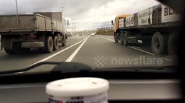 Close Call: Reckless Driver Tries to Slip Through Two Trucks on a Busy Highway
