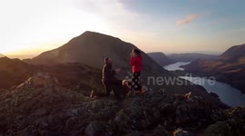 Drone footage shows boyfriend pulling off “ultimate proposal” atop a mountain