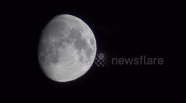 Close-up of the Moon and flying plane