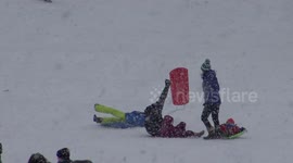 Adults sent flying by kids on sledges