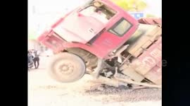 Overloaded truck falls into a sinkhole in the road