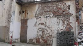 Chinese artist carves vivid image of a face on an old wall