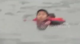 Group of people rescue boy stuck in frozen river
