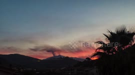 Black smoke spews out of Mount Etna volcano as sun sets