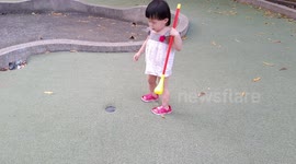 Funny one-year-old girl plays trick on playing golf