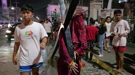 Locals carry large cross through streets in the Philippines on Maundy Thursday