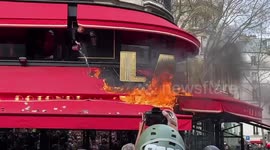 Flare thrown at the police during pension reform protests in Paris misses and sets the roof of the “La Rotonde” cafe on fire