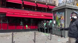 Protesters throw objects at police officers during protest in Paris over pension reform bill