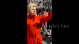 Man in Trump mask being interviewed during protest in New York, USA