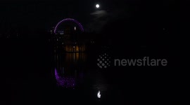 'Super Pink Moon' rises in the sky over St James Park and the London Eye