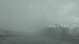 Watch as an intense thunderstorm reduces I-94 visibility almost to zero during a severe storm outbreak in Michigan