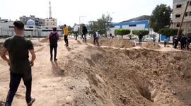 Locals look at huge craters left by air strikes on Gaza after rockets fired into Israel