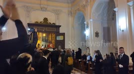 Statue of dead Jesus enters the church welcomed by the faithful, during the Easter procession, which was held in the city of Maddaloni (CE).