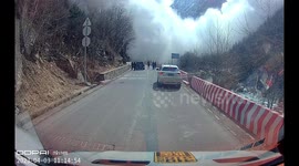 Cars reverse to avoid avalanche crashing down mountain opposite Chinese highway