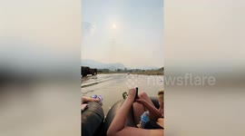 Backpackers marvel at elephants while river tubing in Thailand