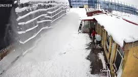 Chinese men narrowly avoid being buried by ice chunks falling off building roof